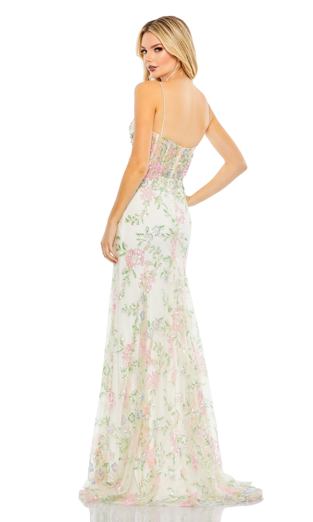 A woman looks over her shoulder against a white background, wearing the Long Formal Dress 68180 by Mac Duggal—a sleeveless, fitted floral gown with thin straps and a delicate pattern.